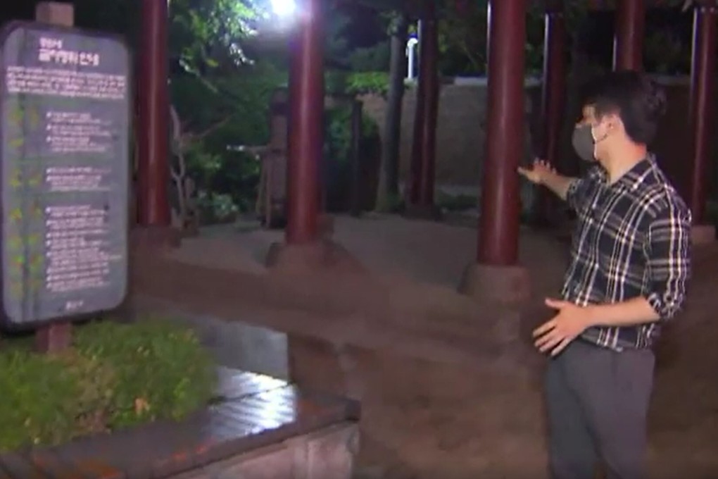 A news reporter points to the scene of the scuffle between the street cleaner and the Belgian ambassador to South Korea’s wife Xiang Xueqiu. Photo: SBS