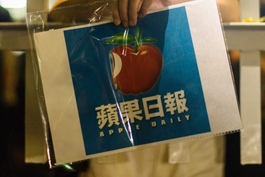 A supporter holds a poster of the Apple Daily newspaper logo outside the media company’s office building in Hong Kong in the early hours of June 24. The European Parliament has adopted a broad new resolution on Hong Kong, advocating tough measures be taken over the government’s crackdown on the city’s press freedom. Photo: AFP via Getty Images/TNS