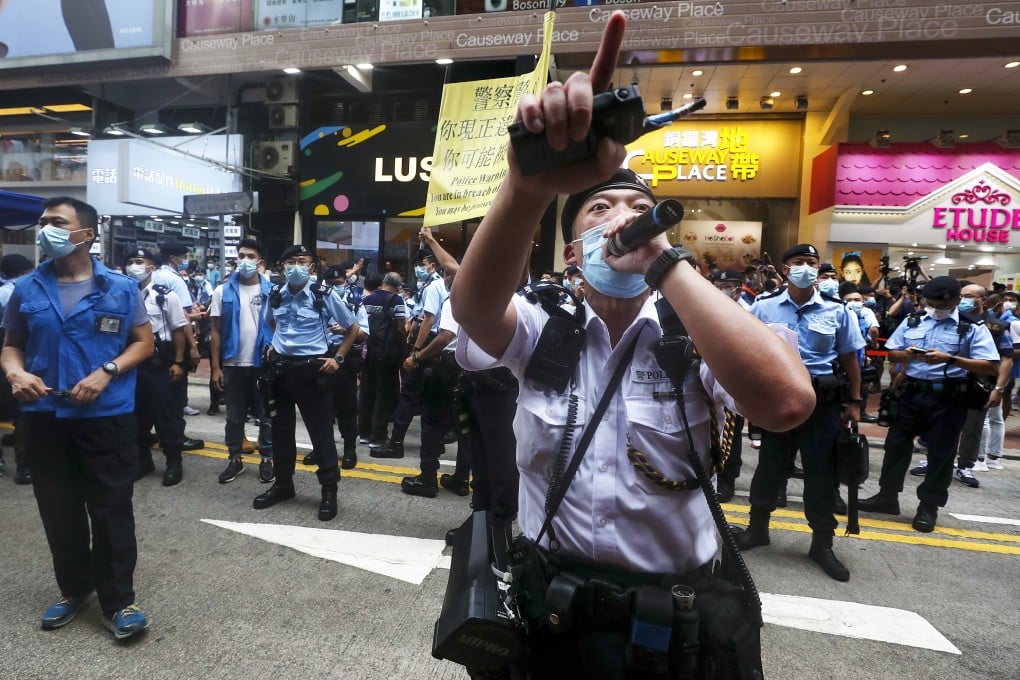 A police officer orders people in Causeway Bay to disperse with a warning that they may be in breach of social-distancing rules. Photo: Xiaomei Chen