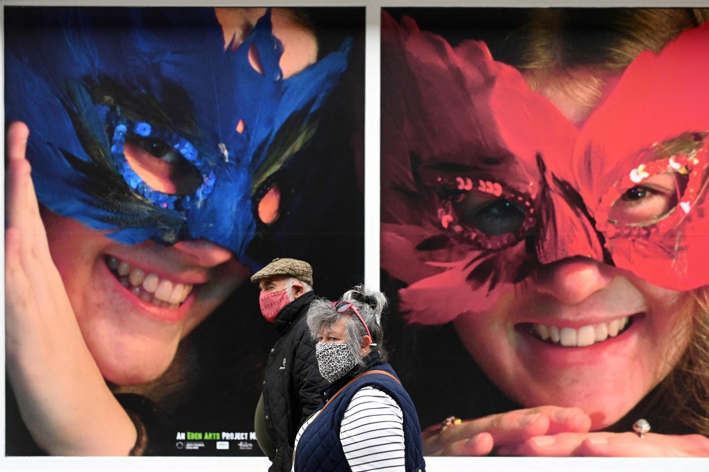 Pedestrians pass posters advertising a festival in Penrith, Cumbria, England. Photo: AFP