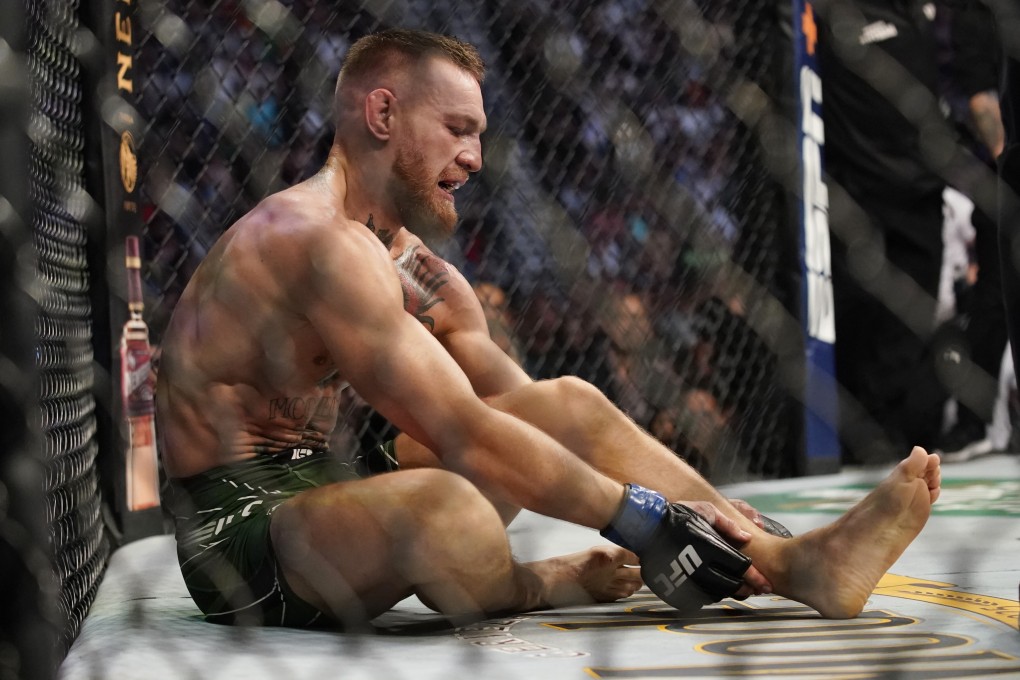 Conor McGregor holds his left ankle at the end of the first round against Dustin Poirier at UFC 264. Photo: Ap