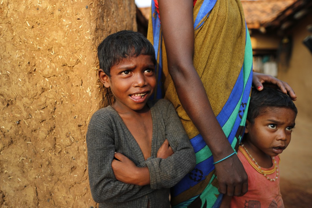 Children watch health workers in India’s Uttar Pradesh last month during a campaign to persuade village elders to get vaccinated against Covid-19. Photo: AP