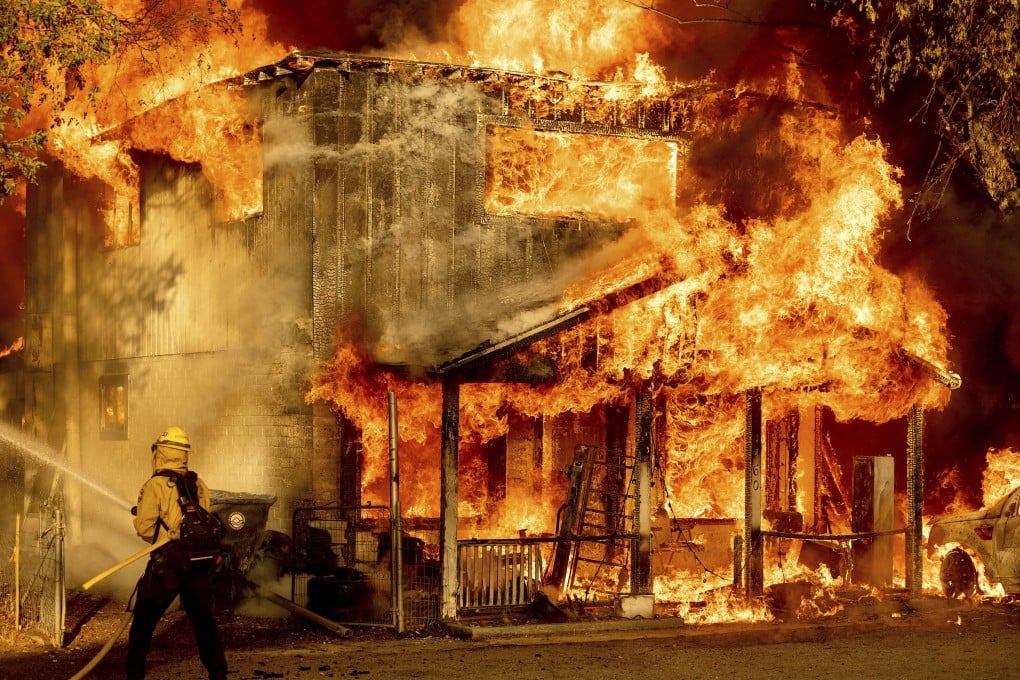 A firefighter sprays water while trying to put out the Sugar Fire, part of the Beckwourth Complex Fire, in Doyle, California on Saturday. Photo: AP