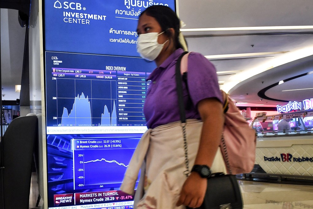 A woman walks past an electronic board showing Asian stock indices and news in a Bangkok mall. Losses in major tech stocks in Hong Kong has surpassed the size of Thailand’s equity market. Photo: AFP
