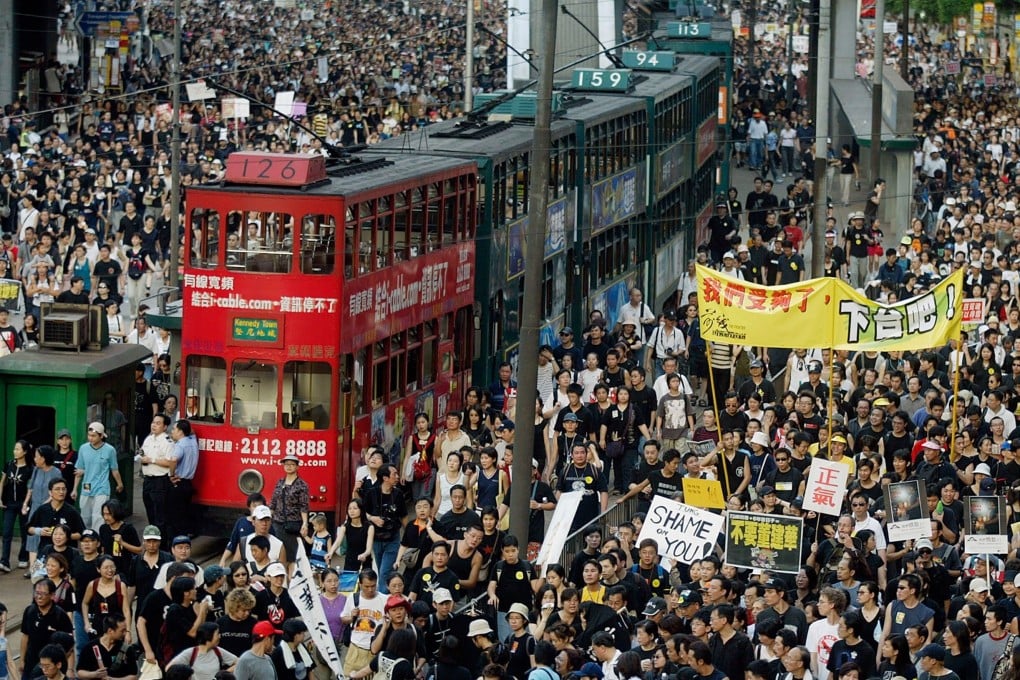 Trams sit stranded as thousands of people block the streets during a protest against Article 23 legislation in Hong Kong on July 1, 2003. Photo: AFP