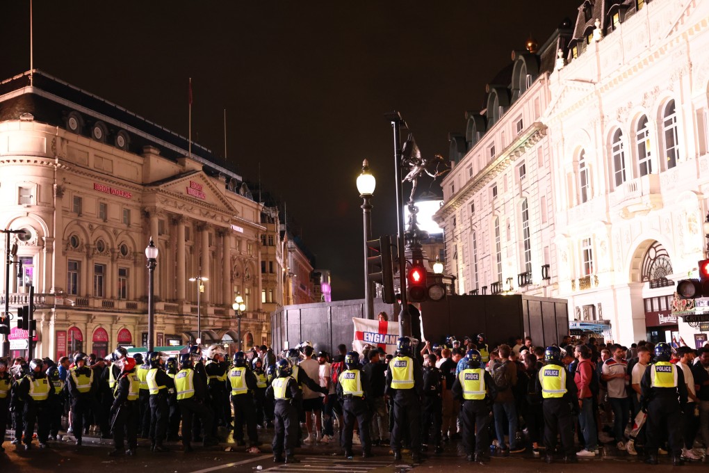 Police officers stand guard as football fans gather in London after Italy won the Euro 2020 against England on Sunday. Photo: Reuters