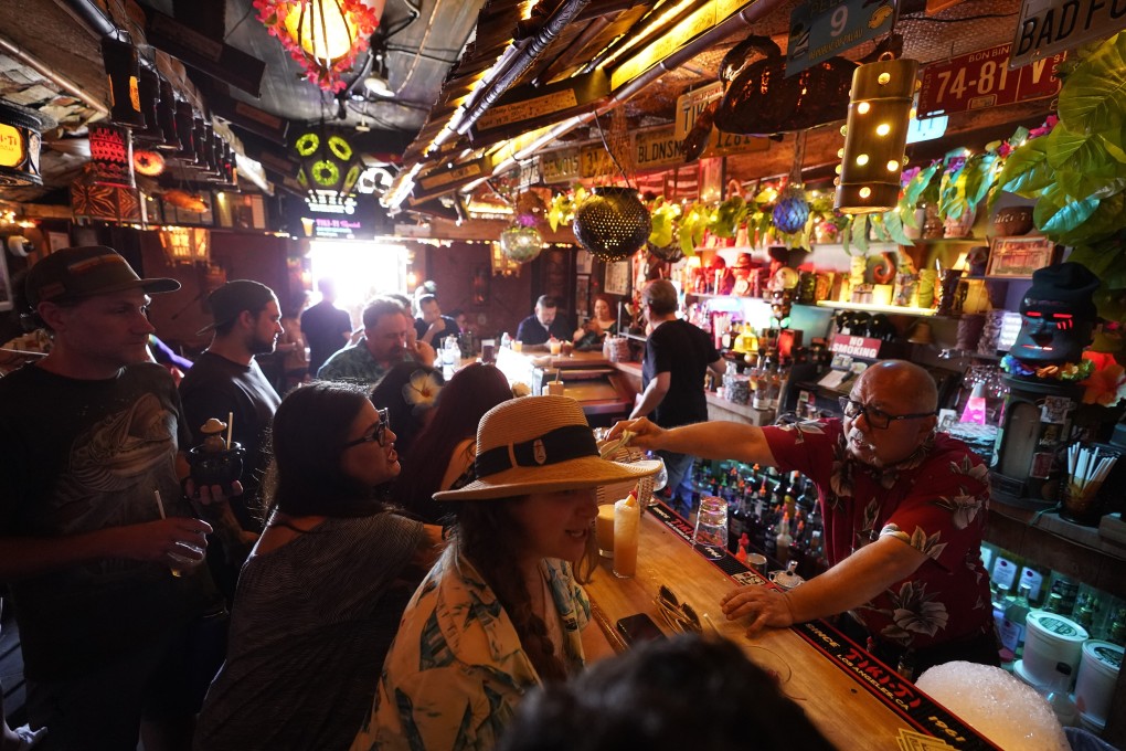 Maskless patrons at the Tiki-Ti bar as it reopens on Sunset Boulevard in Los Angeles, where county public health officials have urged people to resume wearing masks indoors. Photo: AP