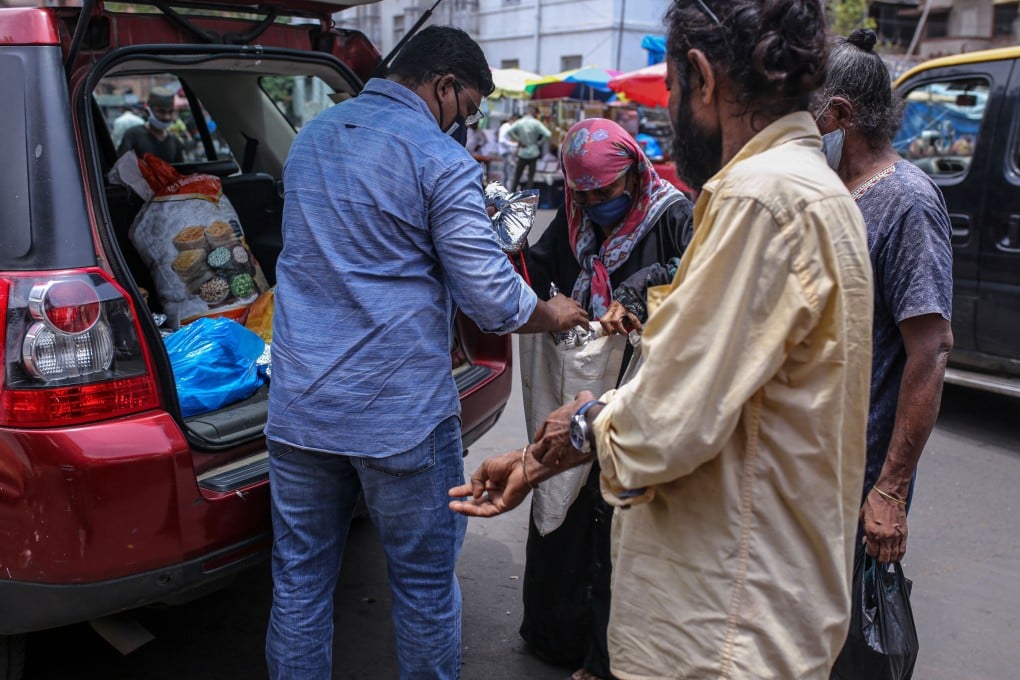 A volunteer for Khana Chahiye, or Want Food collective, distributes free food packs to those in need in Mumbai, India, earlier this month. Photo: Bloomberg