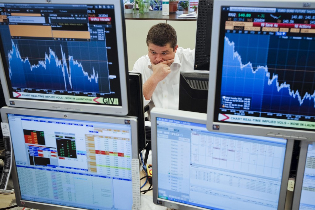 A trader monitoring stock and bond prices on electronic trading terminals. Photo: EPA-EFE