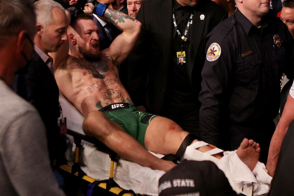 Conor McGregor is carried out of the arena on a stretcher after breaking his leg against Dustin Poirier at UFC 264. Photo: AFP