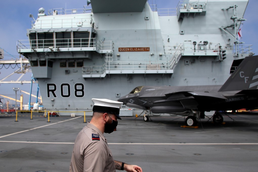 A crew member wearing a face mask walks on the deck of HMS Queen Elizabeth while it was moored at the port of Limassol in Cyprus. Photo: Reuters