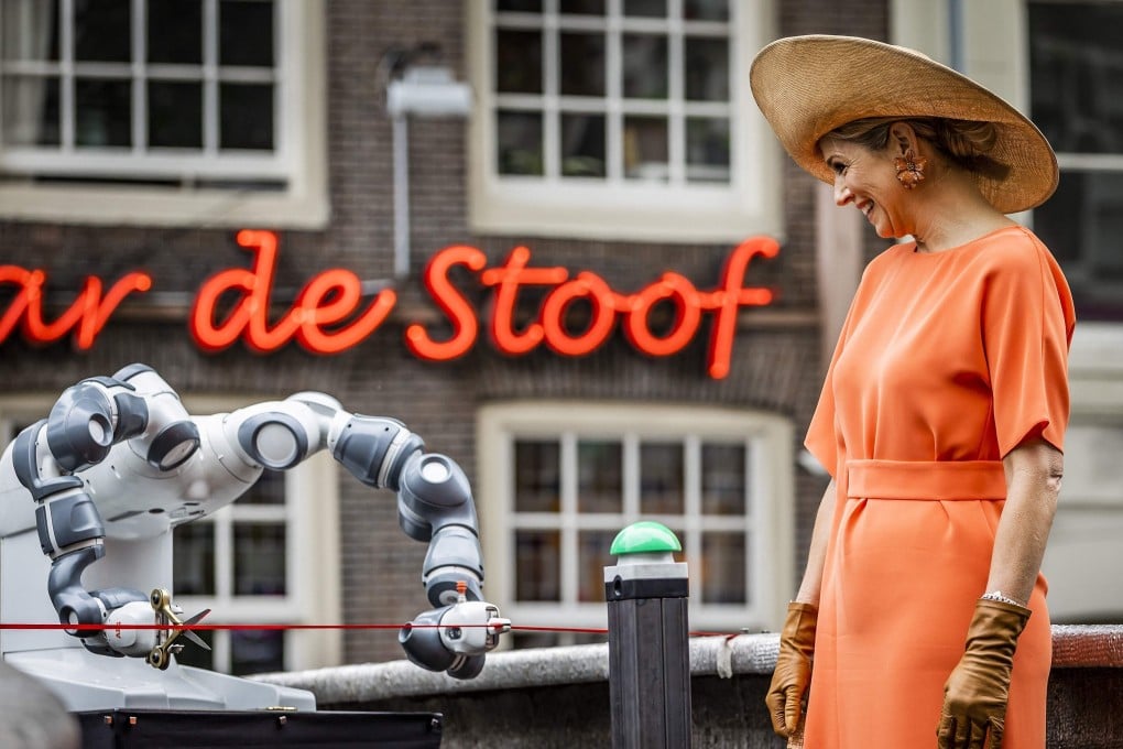 Netherlands’ Queen Maxima watches a robot cutting a ribbon during the opening of a 3D-printed bridge at the Oudezijds Achterburgwal in Amsterdam on Thursday. Photo: ANP / AFP)