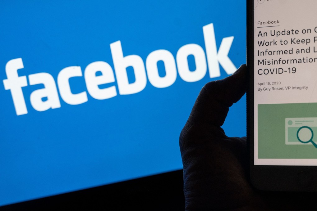 A smartphone screen displays a new policy on Covid-19 misinformation with a Facebook website in the background. Photo: AFP