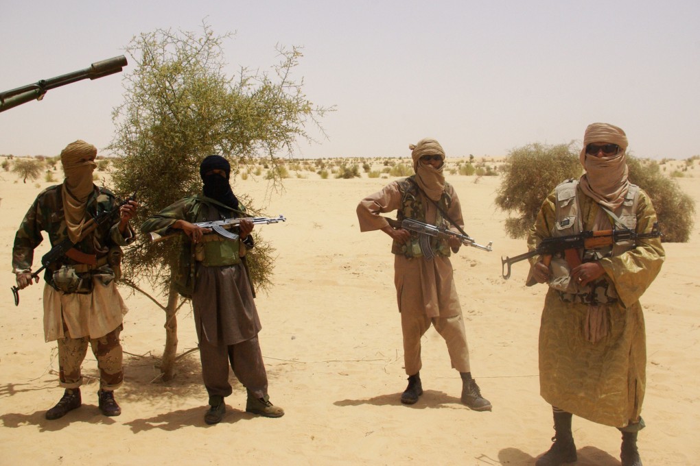 Islamist fighters stand guard during a hostage handover in the desert outside Timbuktu. Mali has been struggling to contain an Islamist insurgency that first broke out in the north of the country in 2012. Photo: AP