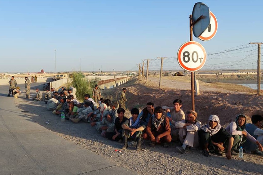 Afghan government soldiers sit at a bridge next to the Tajikistan-Afghanistan border after being forced to retreat by the Taliban. Photo: AP