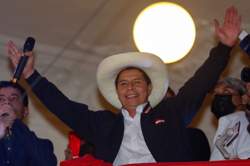 Pedro Castillo raises his arms from the balcony of the Peru Libre party headquarters in Lima. Photo: AFP