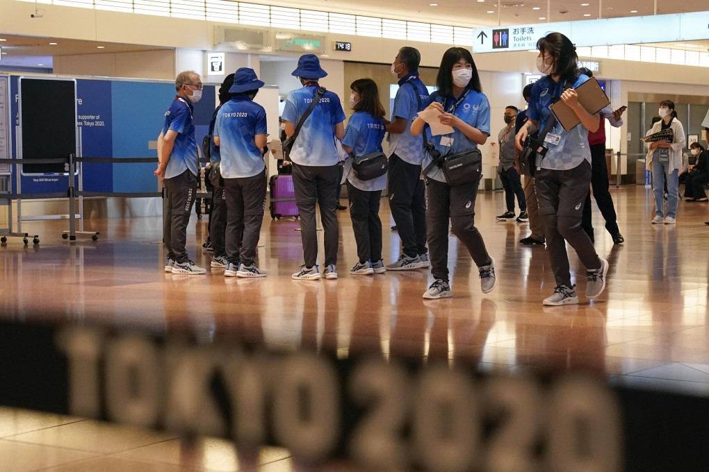 Tokyo 2020 volunteer staff wait for overseas athletes and coaches at Tokyo International Airport on July 8. Photo: EPA