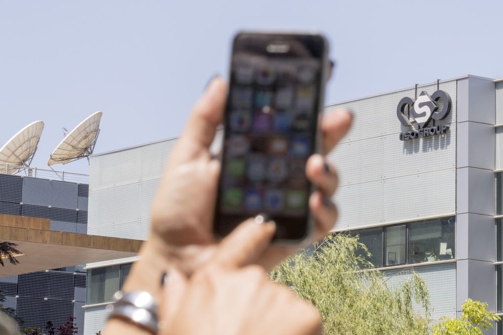 A woman uses her iPhone in front of the building housing NSO group, an Israeli cybersecurity company. Photo: AFP