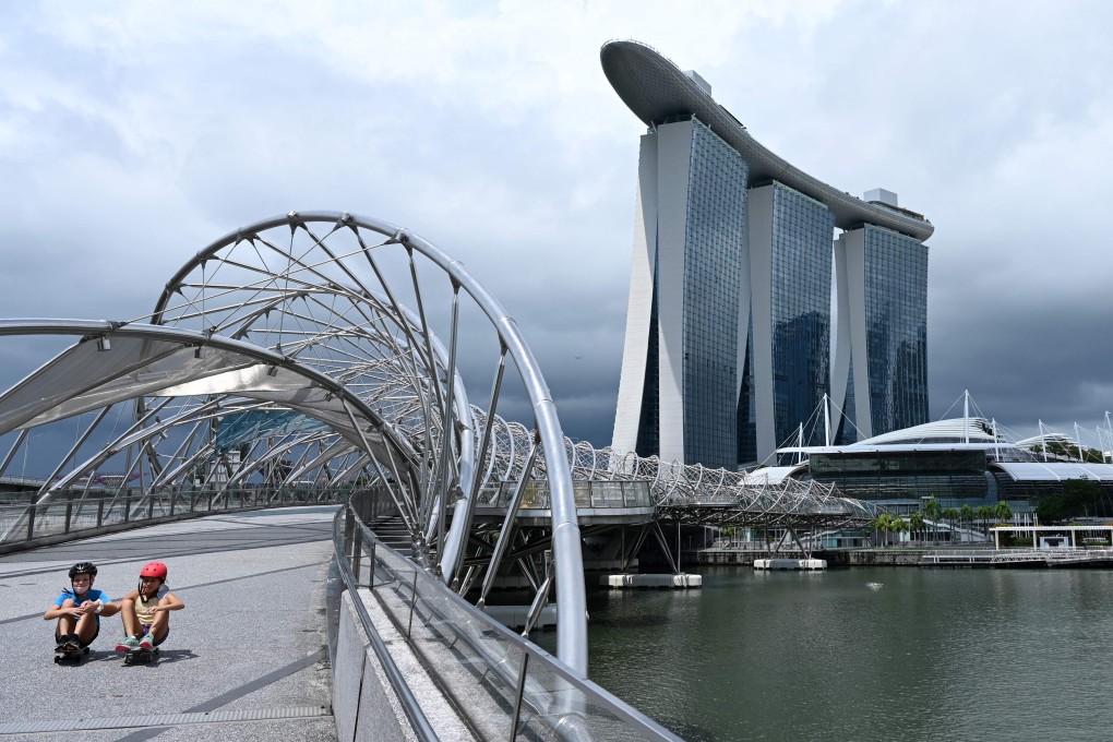 Children ride on skateboards along the Helix Bridge at Marina Bay in Singapore. Photo: AFP