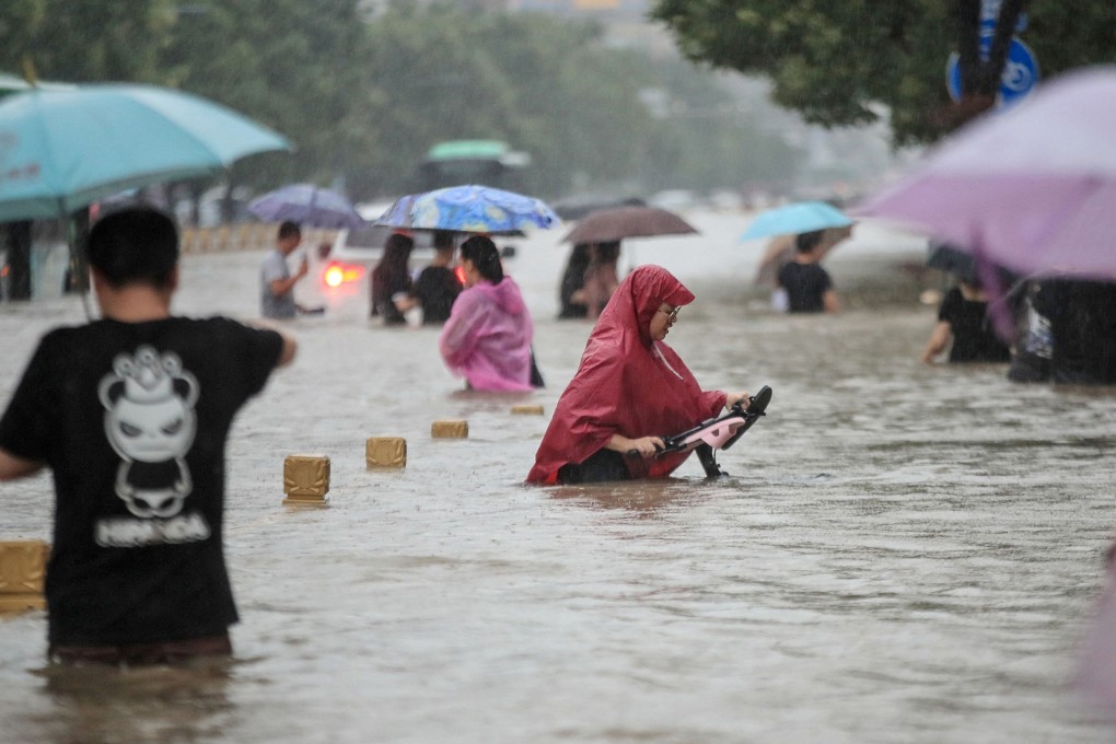 People wading through floodwaters along a street following heavy rains in Zhengzhou in China's central Henan province. Photo: AFP