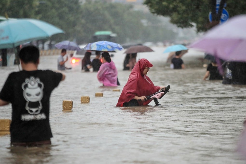 People wading through floodwaters along a street following heavy rains in Zhengzhou in China's central Henan province. Photo: AFP