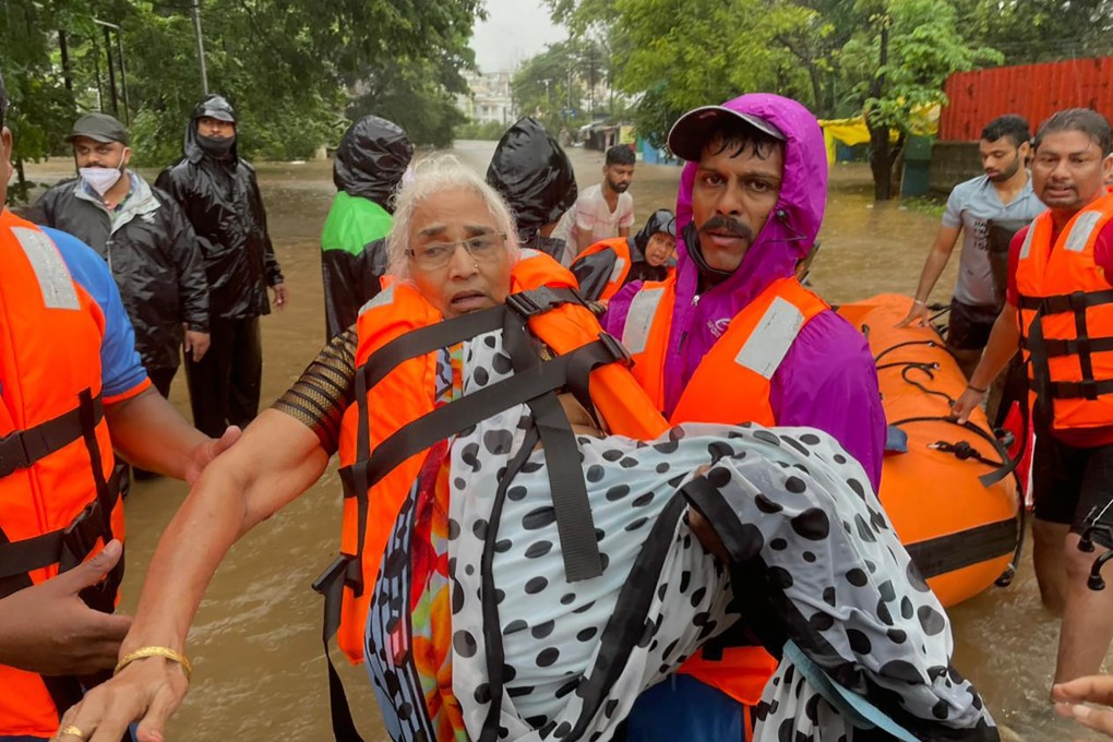 The National Disaster Response Force rescues an elderly woman stranded in floodwaters in Kolhapur, in the western Indian state of Maharashtra. Photo: AP