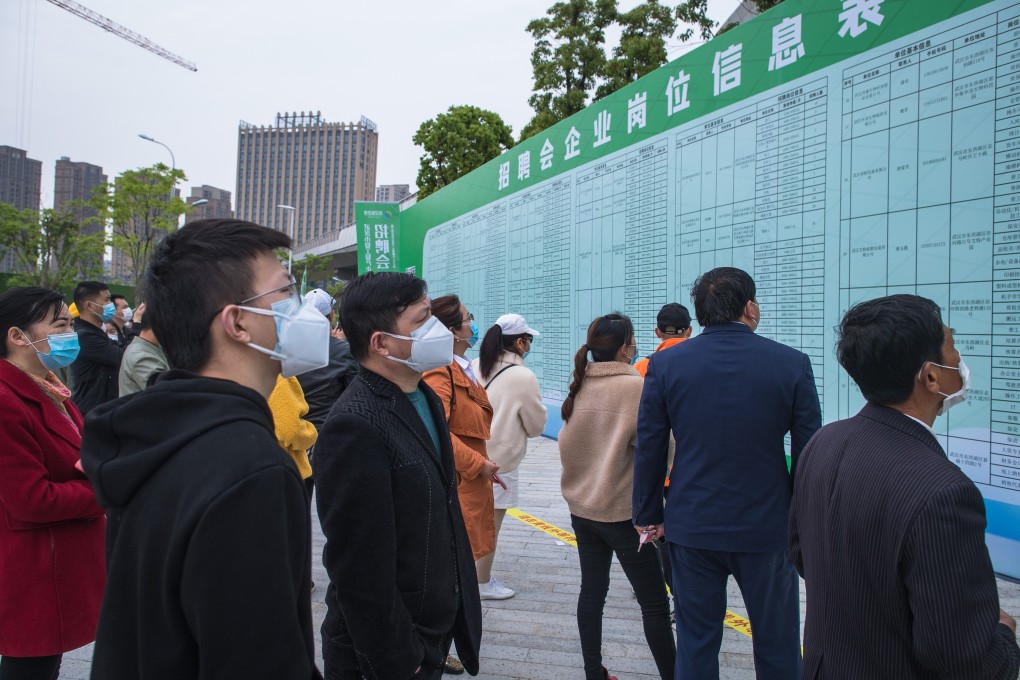 Job applicants read recruitment information at a job fair in Wuhan, in central China’s Hubei province. Photo: Xinhua
