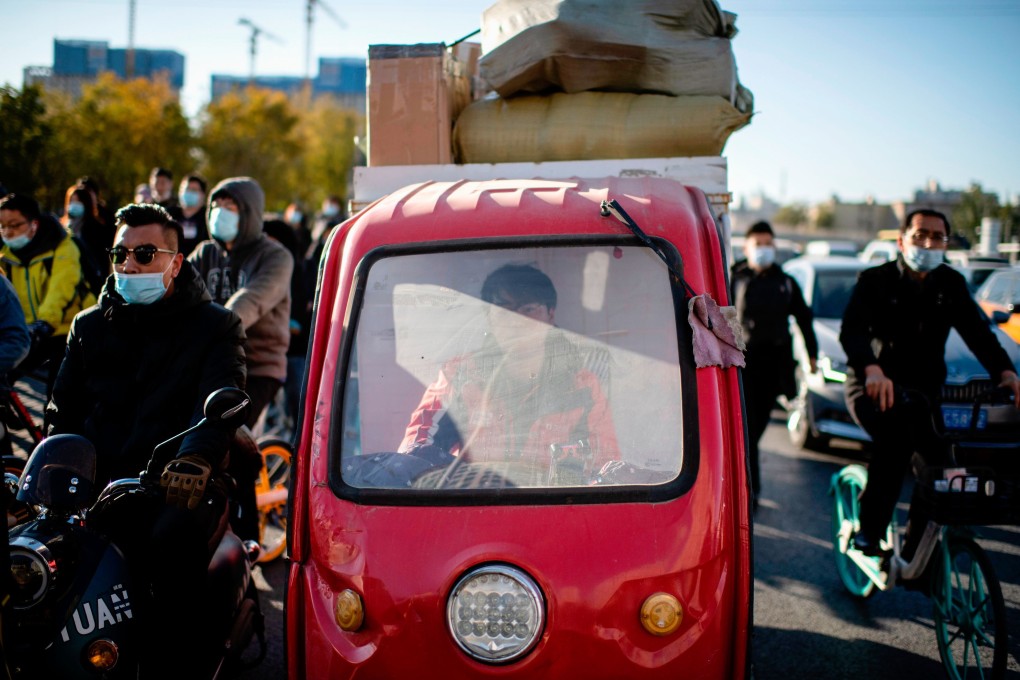 A delivery worker for online sales orders waits in traffic in Beijing on November 9, 2020. Photo: AFP