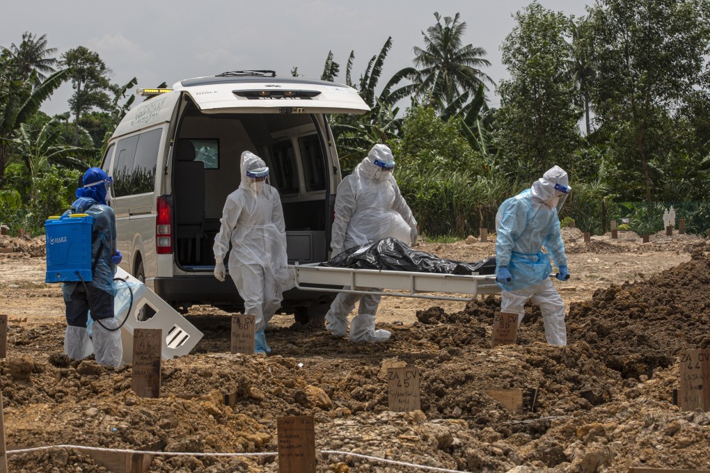 Health workers wearing protective gear carry a body during a funeral for a Covid-19 victim in Klang, near Kuala Lumpur, on Sunday. Photo: EPA
