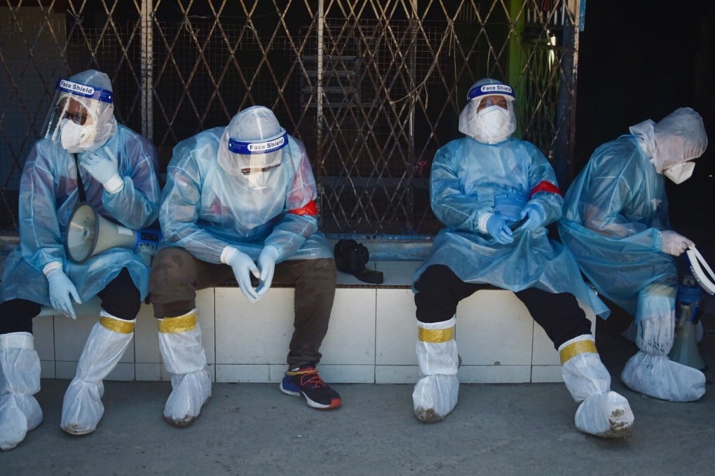 Malaysian health workers rest after conducting Covid-19 tests at a refugee camp in Kiamsam, Labuan. Photo: Bernama/dpa