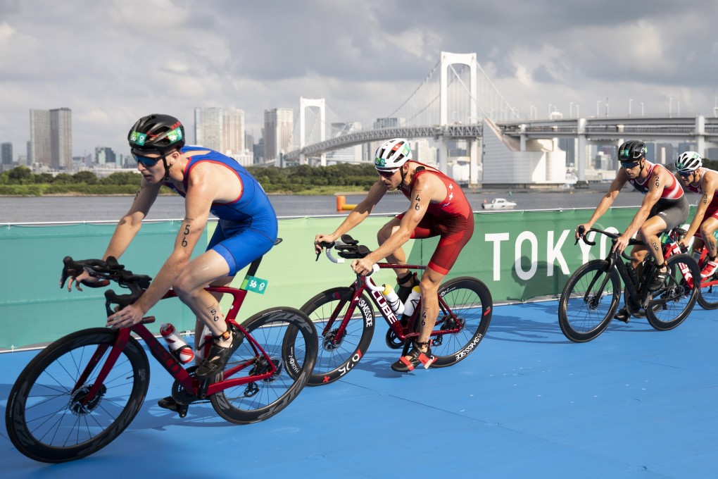 Hong Kong’s Oscar Coggins leads Switzerland’s Andrea Salvisberg in the bike leg of the men’s triathlon at the Tokyo Olympics on Monday. Photo: EPA-EFE