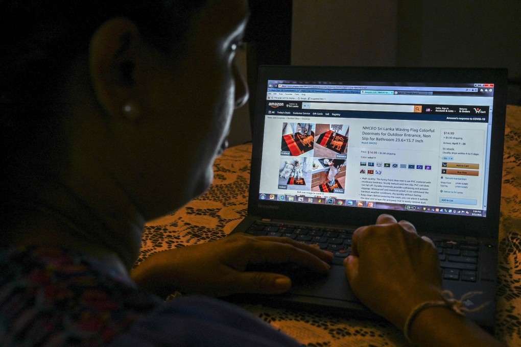 In this photo illustration a woman looks through a webpage of the online retail giant Amazon displaying Chinese-made doormats with the Sri Lankan flag design for sale in Colombo on March 12. Amazon has been cracking down on Chinese merchants this year, banning those that violate its rules like paying for positive reviews. Photo: AFP