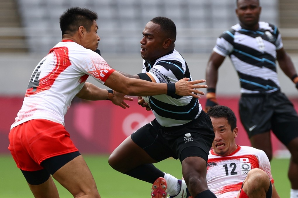 Fiji rugby sevens player Waisea Nacuqu gets beyond tackles from Kazushi Hano and Naoki Motomura of Japan in their opening Tokyo 2020 Olympic Games match in the Tokyo Stadium. Photo: Reuters