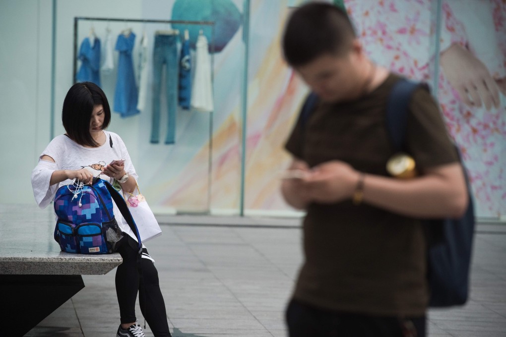 People use their smartphones along a street in the southern Chinese city of Shenzhen. Photo: AFP