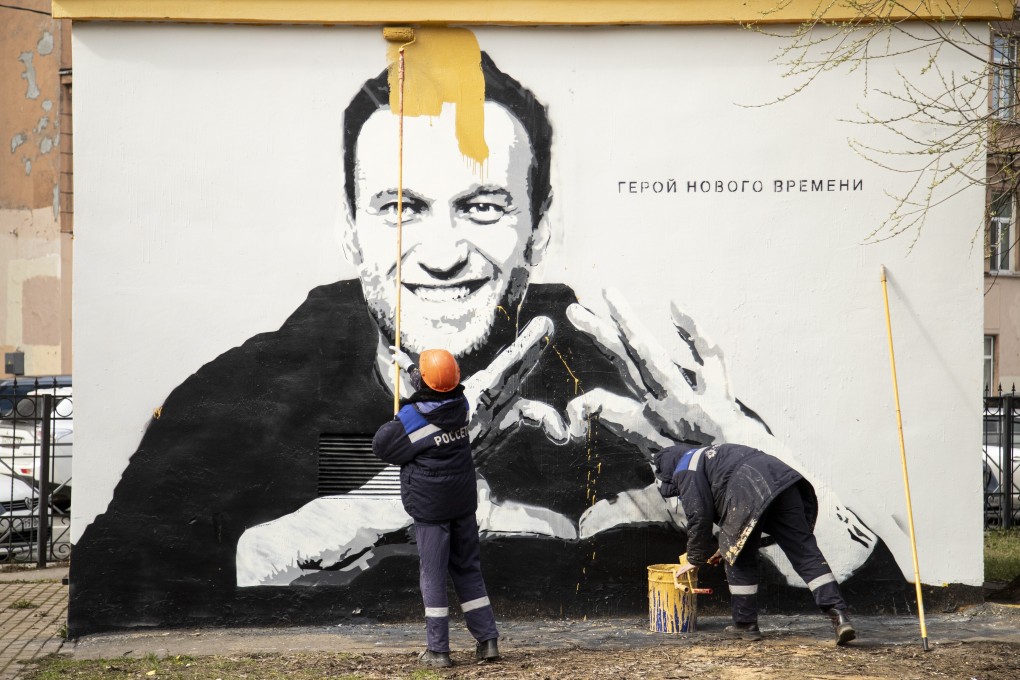 Municipal workers paint over graffiti of Alexei Navalny in St. Petersburg, Russia, in April. Photo: AP