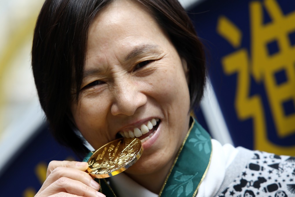 Lee Lai-shan bites on her gold medal during a function at the Happy Valley Racecourse in 2016. Photo: Sam Tsang