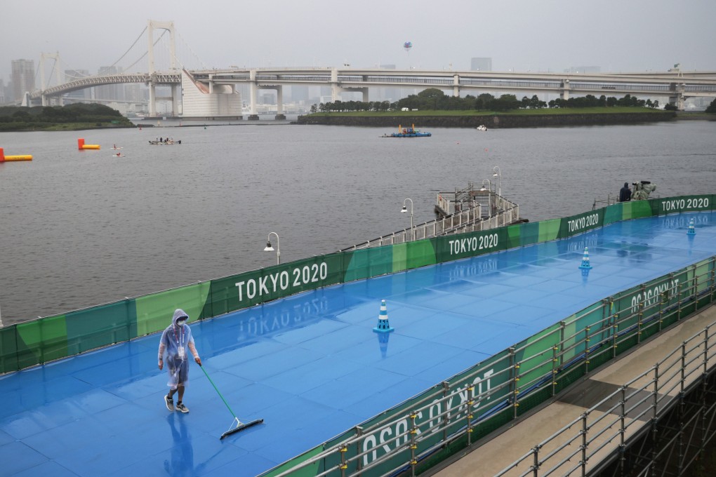 A Tokyo Olympics worker prepares the triathlon track in Odaiba Marine Park during rainy weather in the Japanese capital on Tuesday. Photo: Reuters