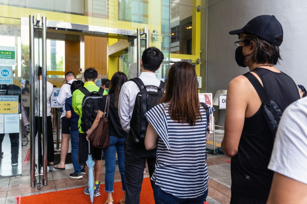 People await their Covid-19 jabs at a community vaccination centre in Hong Kong. It is imperative to get as many people vaccinated as possible to allow curbs to be eased without endangering public health. Photo: Bloomberg