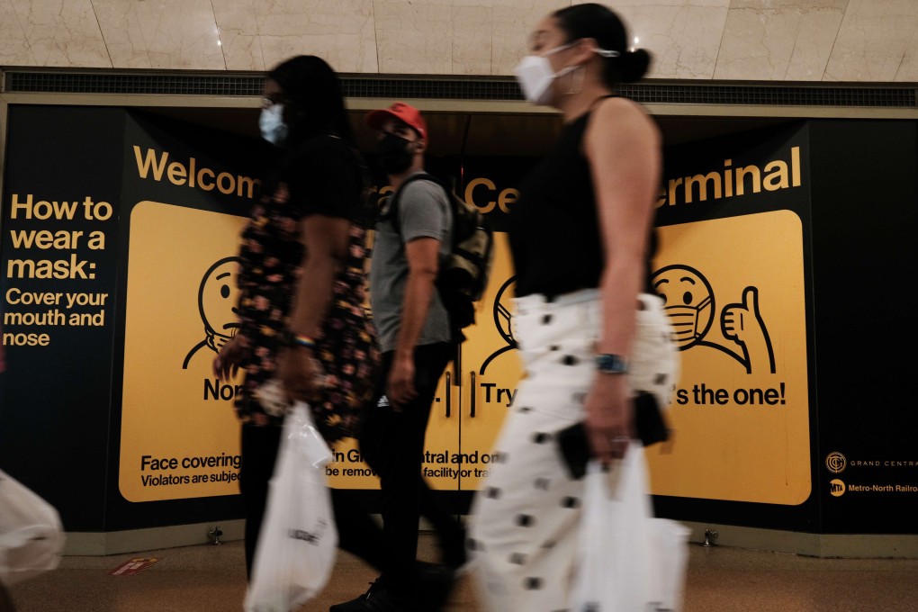 People wear masks while walking inside Grand Central Terminal in New York City on Tuesday. Photo: AFP