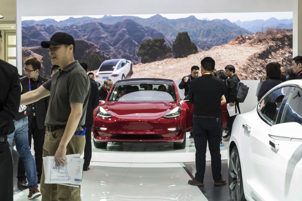 Visitors look at a Tesla Model 3 electric vehicle at the Beijing International Automotive Exhibition in Beijing. Photo: Bloomberg