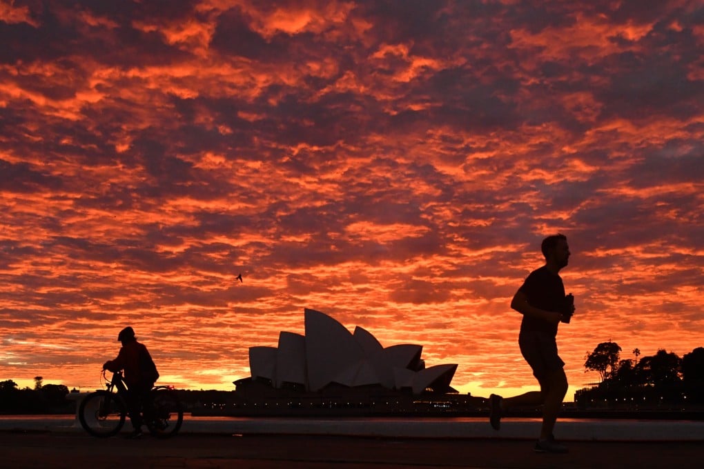 A jogger runs past the Opera House at dawn in Sydney. Photo: AAP Image/DPA