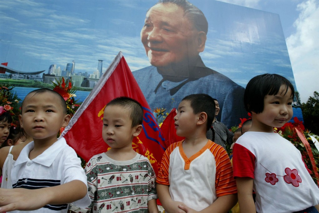 Kindergarten students stand in front of a billboard featuring a portrait of Deng Xiaoping in Shenzhen to mark the 100th anniversary of the birth of the late paramount leader on August 22, 2004. The city, one of the youngest in China, is set to become the first in the country to guarantee spots for children in local kindergartens. Photo: Reuters