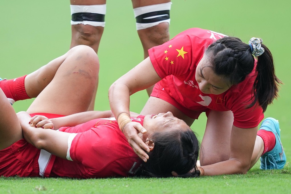 China women’s sevens rugby player Chen Keyi is consoled by teammate Liu Xiaoqian after sustaining an injury in the fifth-to-eighth placing match against the USA in Tokyo Stadium. Photo: Xinhua