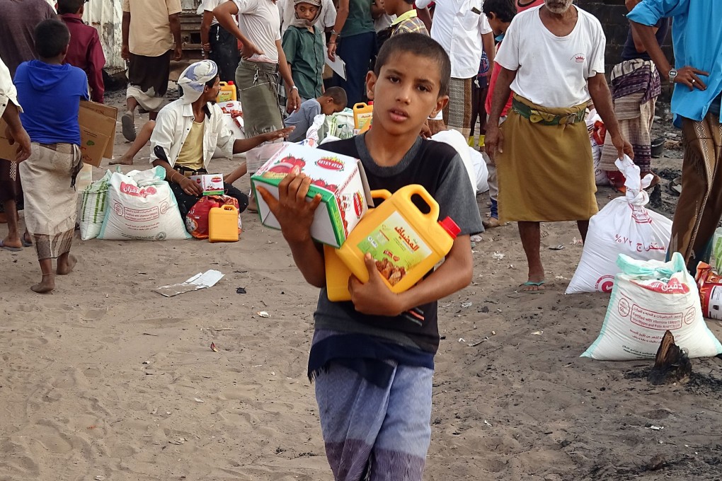 Internally displaced Yemenis whose camp was ravaged by fire receive food aid in a village near the port city of Hodeida earlier this month. Photo: AFP