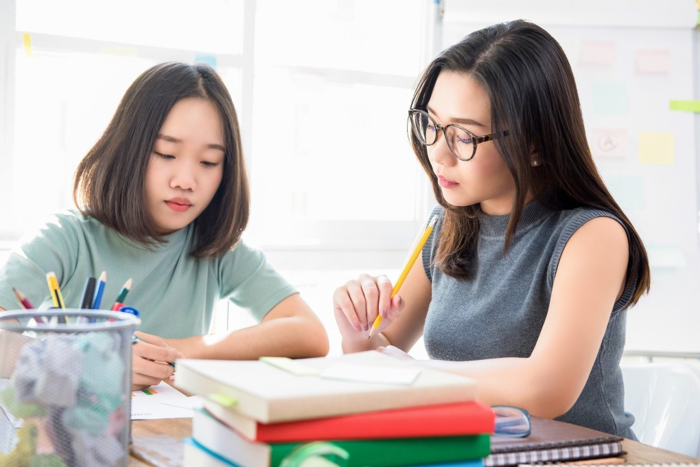An Asian or Chinese tutor teaches a girl. Photo: Shutterstock