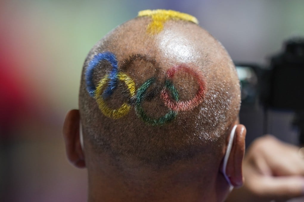 Mongolian coach Undralbat Lkhagva has the Olympic rings cut and dyed into his hair as he watches the women’s 10m air pistol at the Asaka Shooting Range in Tokyo. Photo: AP Photo