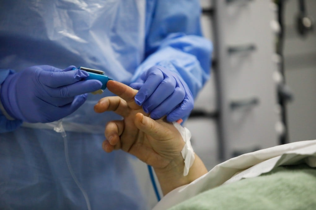 A medical worker applies a pulse oximeter on a patient. Photo: Reuters