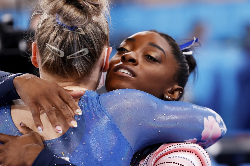 Simone Biles hugs Ellie Black, of Canada, during the women’s balance beam final at the Tokyo Olympic Games. Photo: EPA
