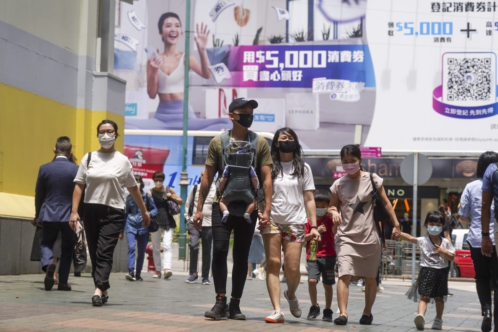 A billboard touting the government’s HK$5,000 voucher scheme looms above pedestrians in Hong Kong’s Tsim Sha Tsui shopping district. Photo: Sam Tsang