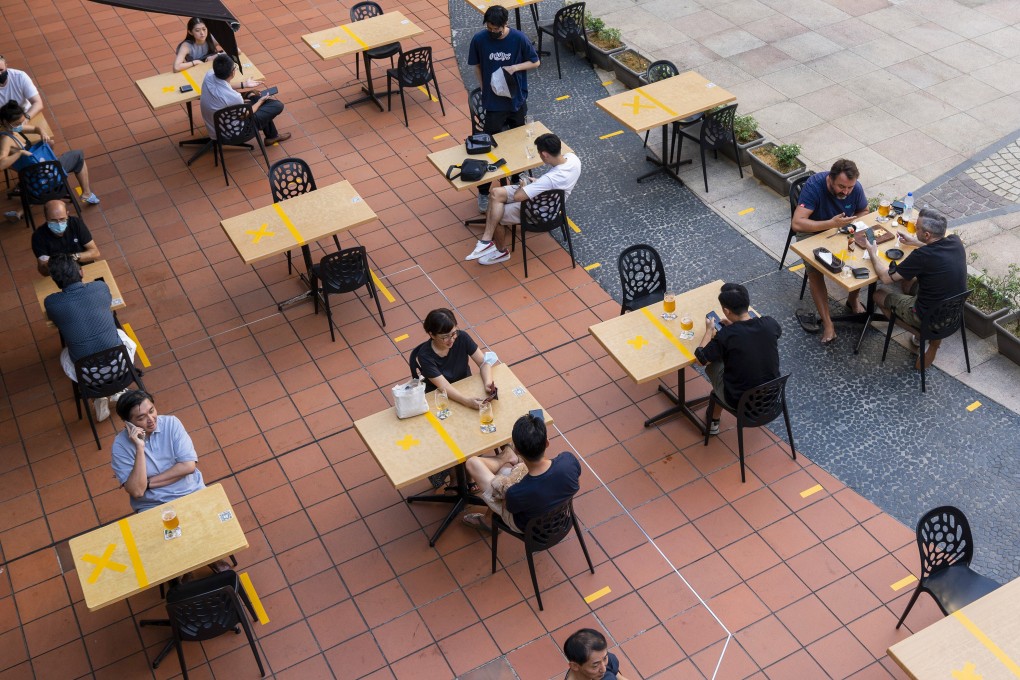Customers sit at socially distanced tables outside a restaurant in Singapore. Photo: Bloomberg
